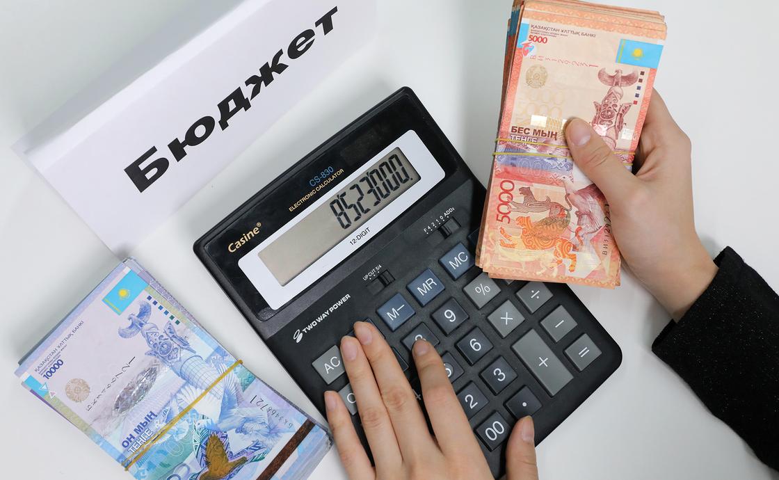 Женщина считает деньги на калькуляторе Женщина считает деньги на калькуляторе