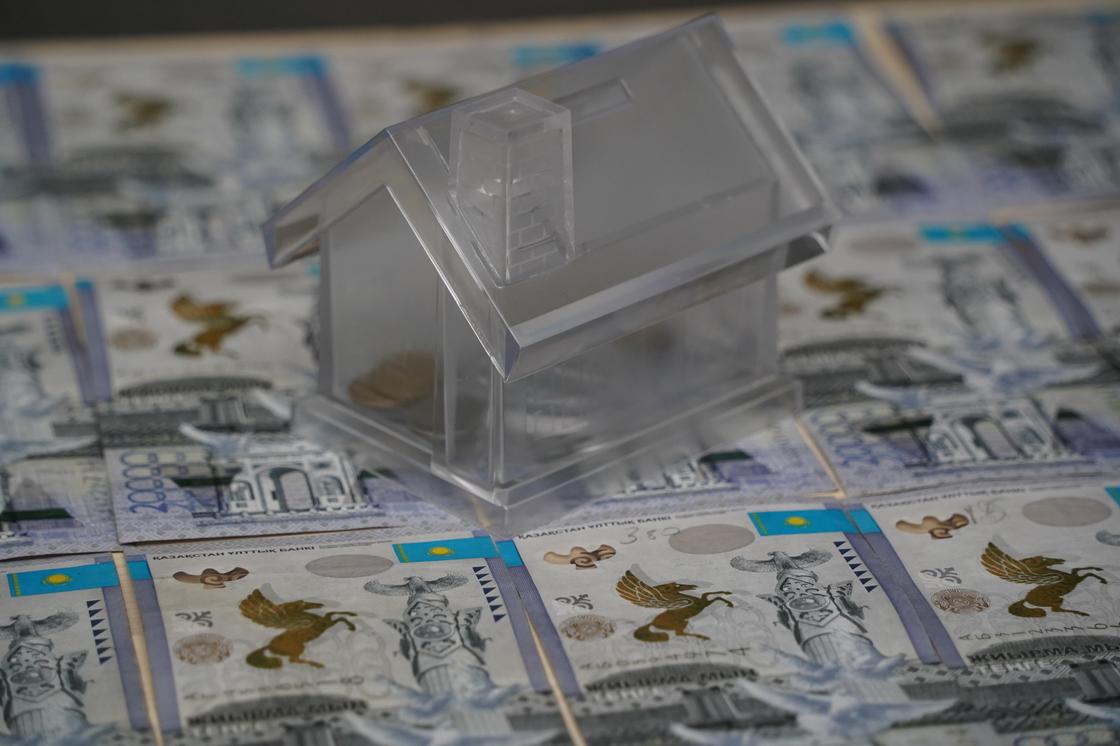 деньги на ипотеку. домик-копилка стоит на деньгах деньги на ипотеку. домик-копилка стоит на деньгах