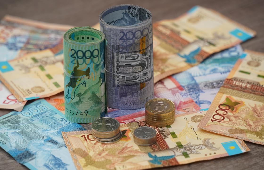 Два денежных ролла стоят на купюрах тенге
