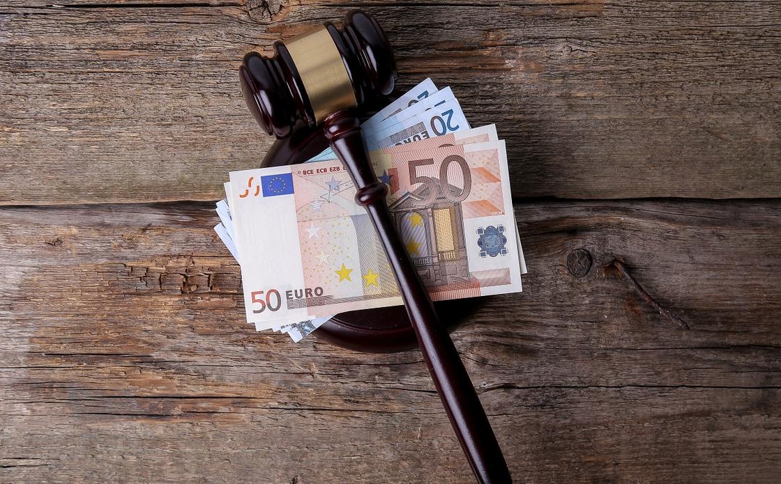 Молоток судьи лежит на купюрах