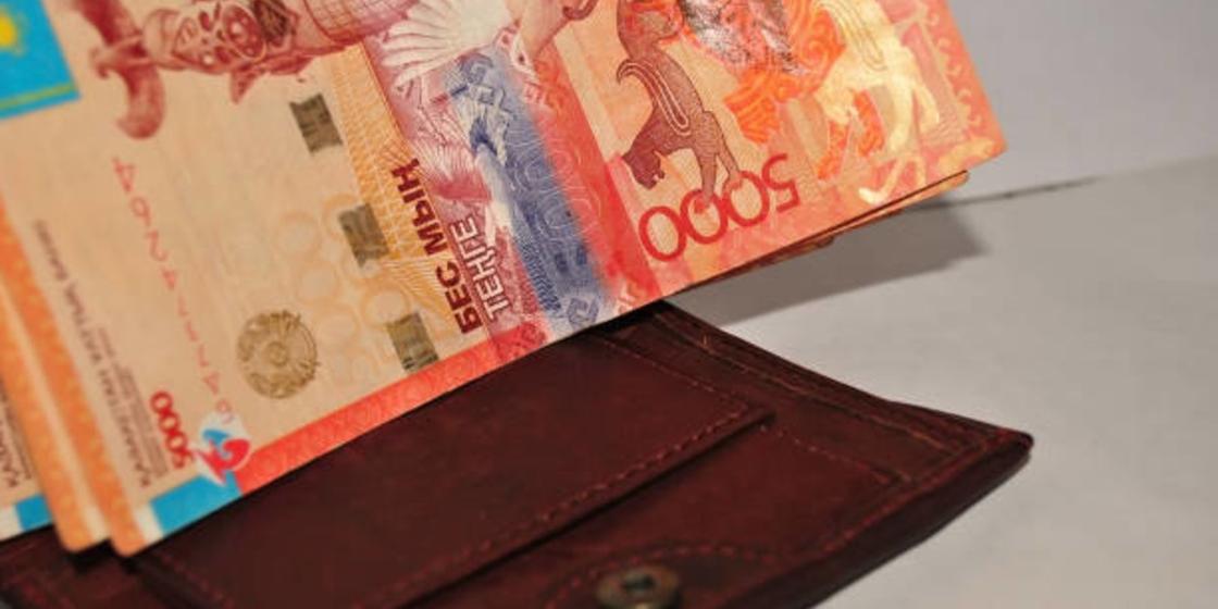 Бумажные купюры тенге и кошелек Бумажные купюры тенге и кошелек