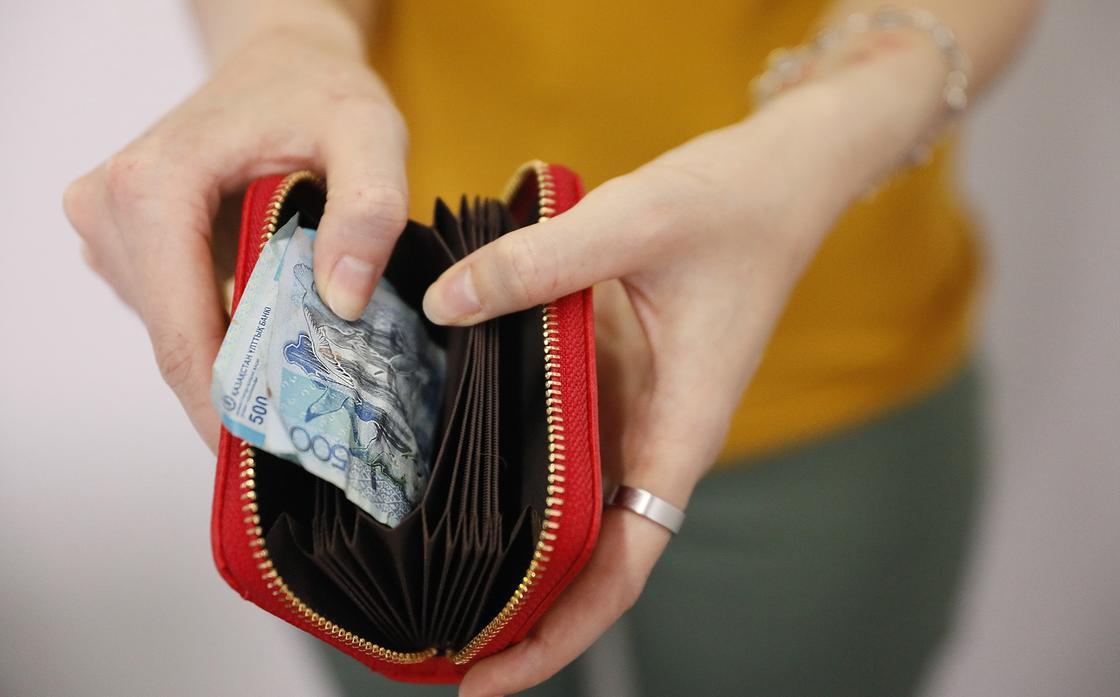 Девушка держит в руках пустой кошелек