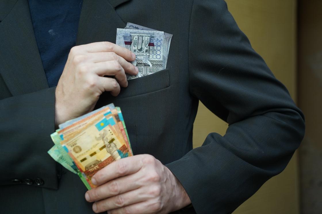 Мужчина кладет деньги в нагрудный карман Мужчина кладет деньги в нагрудный карман