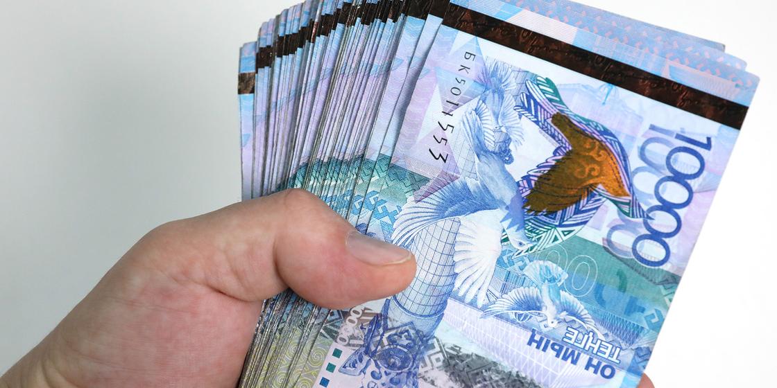 Мужчина держит в руках пачку денег Мужчина держит в руках пачку денег