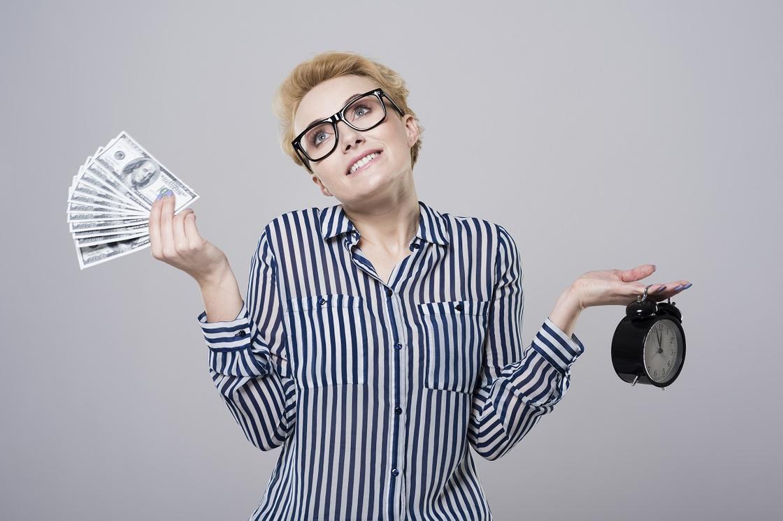 Женщина держит деньги и часы Женщина держит деньги и часы