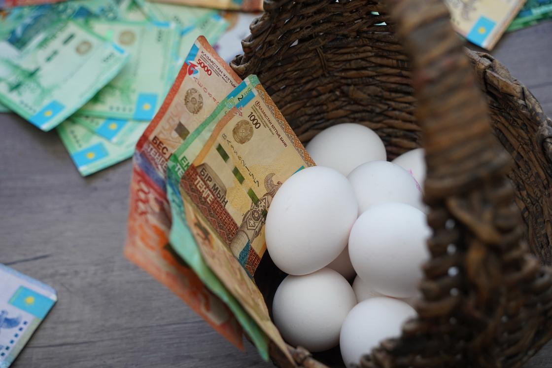 Яйца лежат в корзинке вместе с купюрами тенге Яйца лежат в корзинке вместе с купюрами тенге