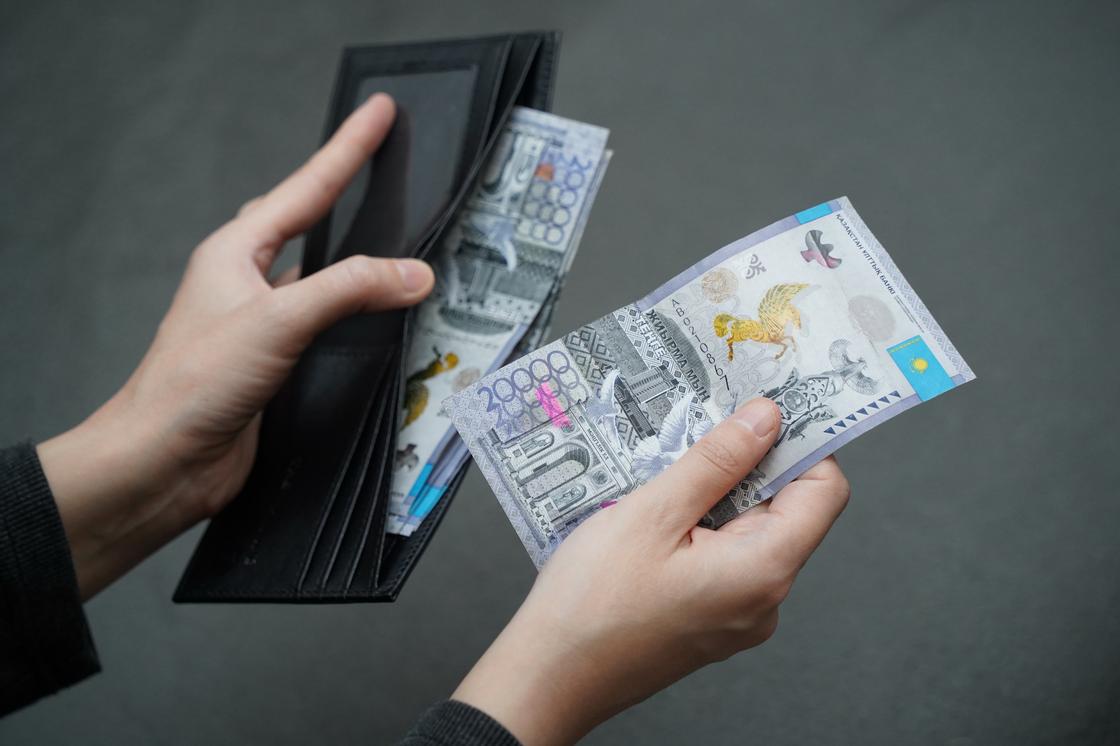 Мужчина держит в руках кошелек с деньгами