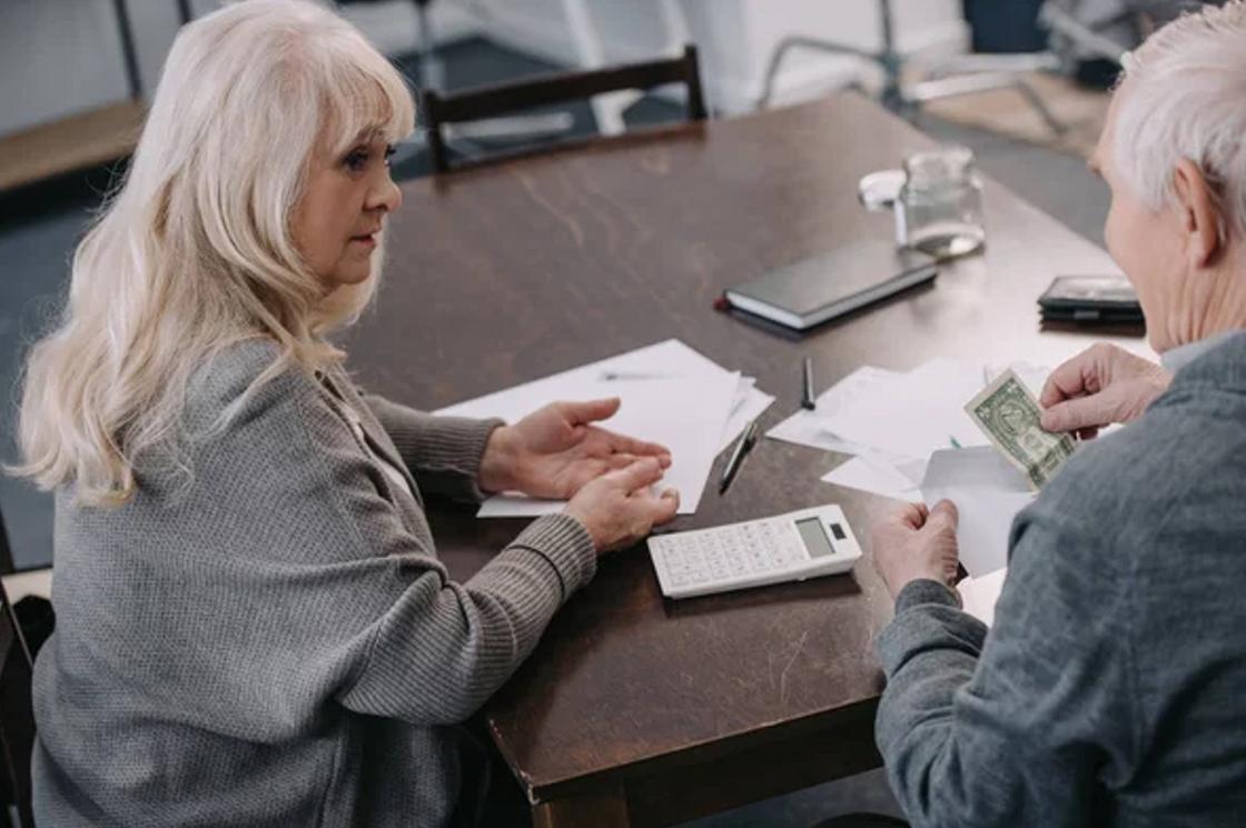 Пожилая пара за расчетами