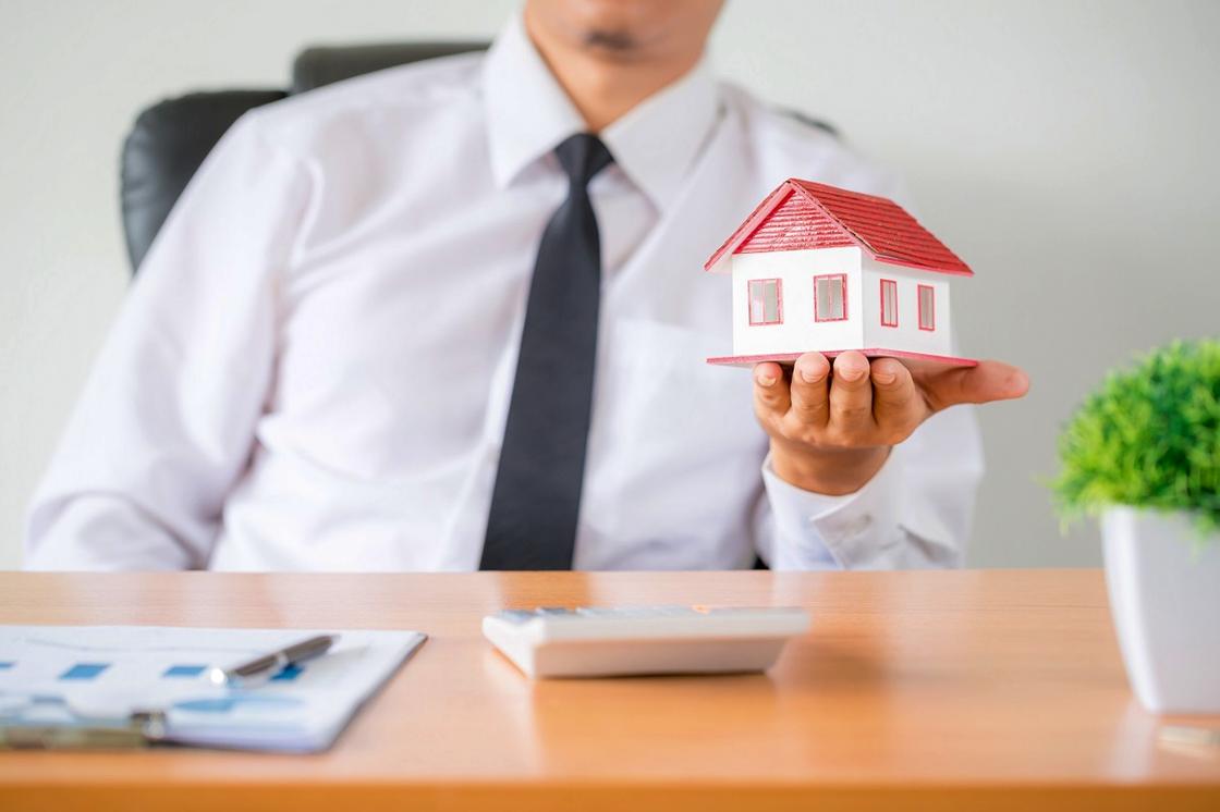 Мужчина держит модель дома