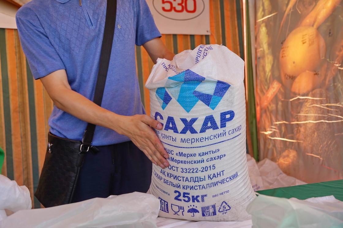 Мужчина держит мешок с сахаром Мужчина держит мешок с сахаром