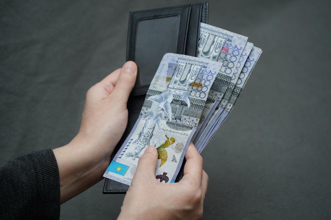 Девушка держит портмоне с деньгами в руках Девушка держит портмоне с деньгами в руках