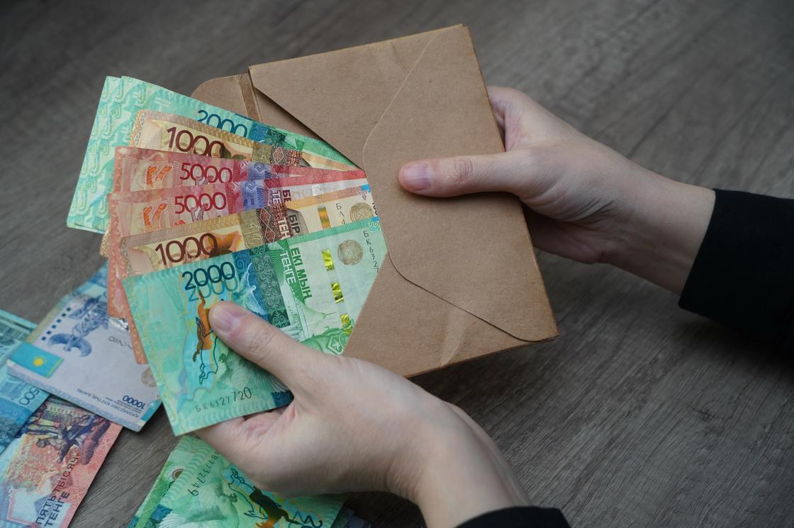 Женщина достает из конверта деньги