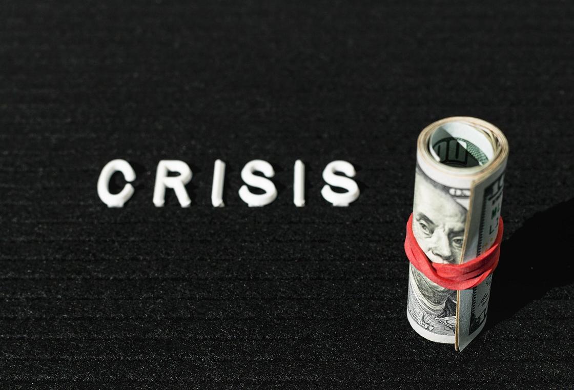 Надпись "кризис" и ролл долларов