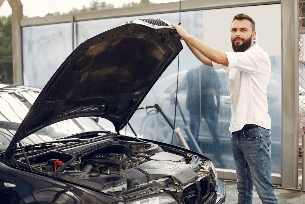 handsome man checks engine his car - Bizmedia.kz